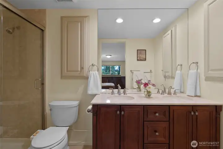 Primary bath offers a double vanity, marmoleum floors and a large shower.