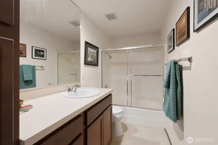 Hall full bath offers great storage, marmoleum floors, large vanity and tub shower.