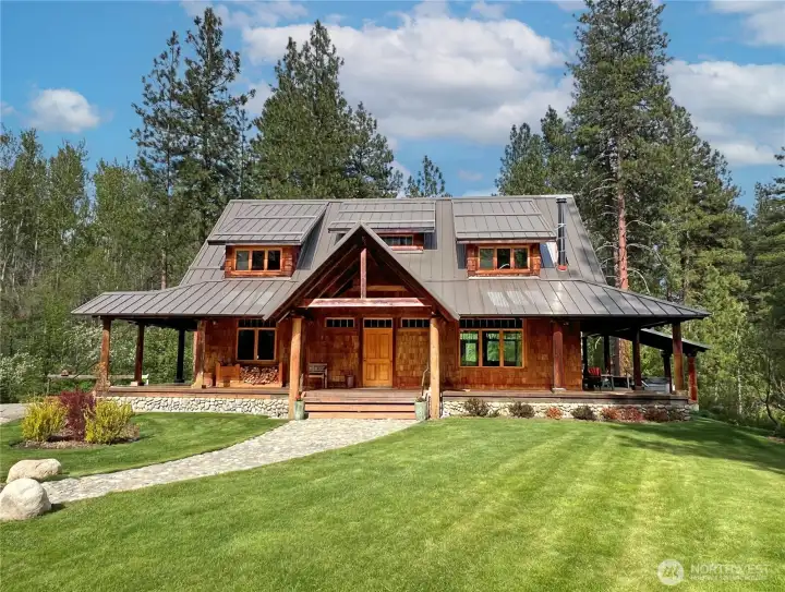 Arrival at a private Northwest retreat—custom main home and detached shop/garage set among towering pines and beautiful meadows