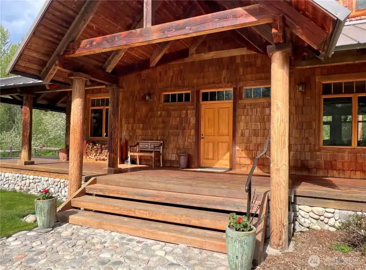 Artisan-crafted entry with hand-built railings, rich shake siding, and timber accents—an inviting sense of arrival that reflects the quality and character of a true luxury Northwest home