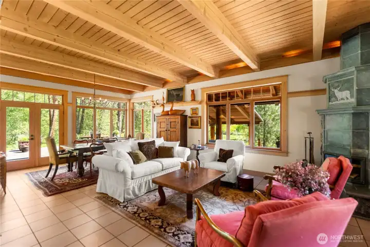 Great room with wood ceilings and walls of windows, soft valance lighting, —designed for gathering, comfort, and easy indoor-outdoor flow