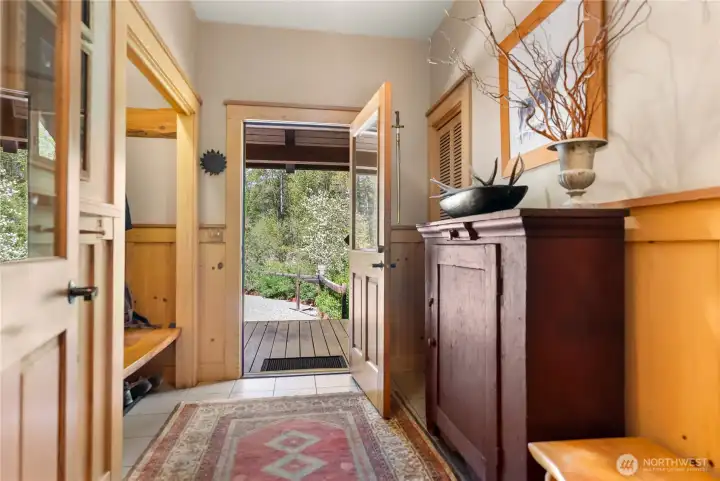 “Methow Mudroom” back entry from the garage, thoughtfully designed with tile flooring, built-in bench seating, and closet storage—perfect for organizing gear in every season