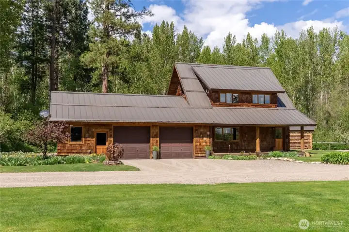 Detached 4-car garage with heated workshop and built-in workbench, dedicated gear room, and exceptional guest accommodations—studio apartment above with propane freestanding stove, kitchenette, and bath with shower, plus a lower-level bunk room ensuite and on-demand hot water system