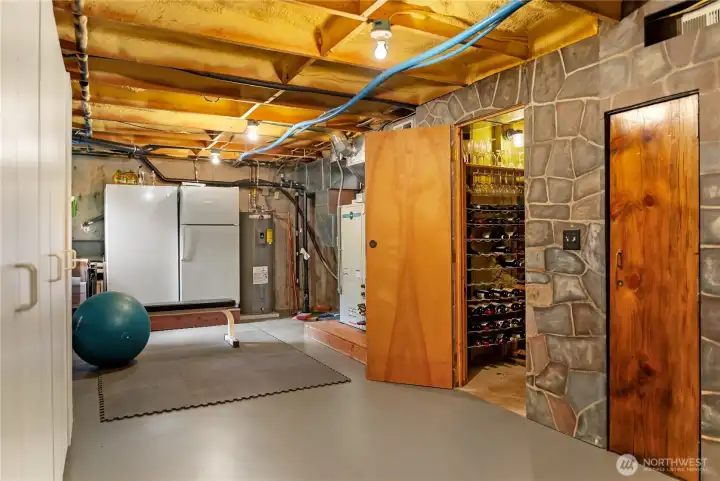 Lower level offering far more than a typical utility space—featuring an extra refrigerator/freezer, abundant shelving and storage, and a highly efficient, high-end geothermal heating and cooling system. Also includes a temperature-controlled wine cellar and a private locking home vault