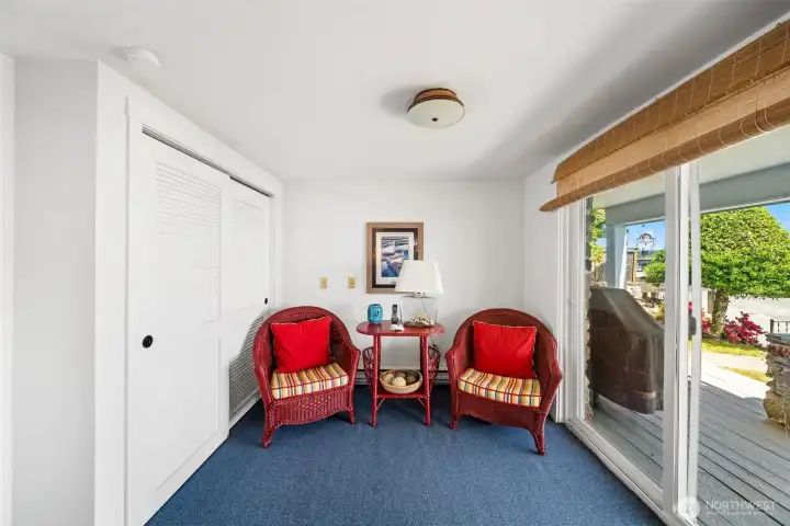 The other end of the bonus room on the lower level shows slider to covered rear deck and the waterfront.