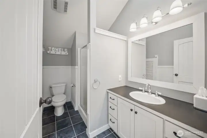 Bath for the apartment offers linen storage, plenty of counter space