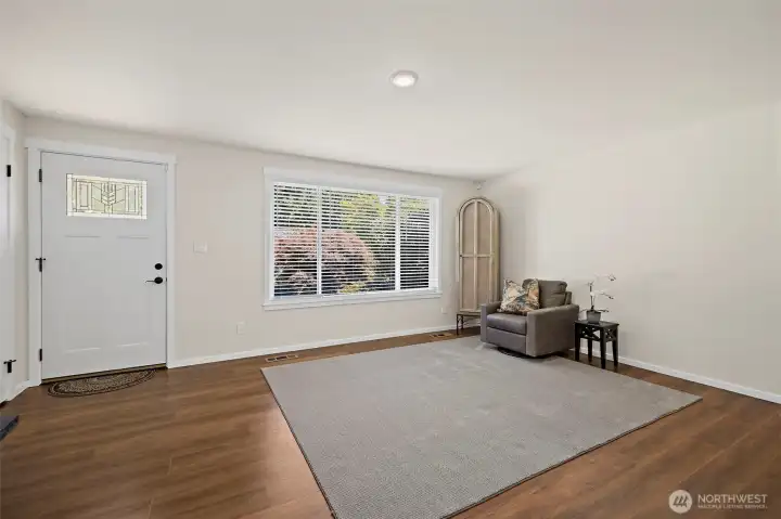 Spacious living room with large window allows for plenty of natural lighting.
