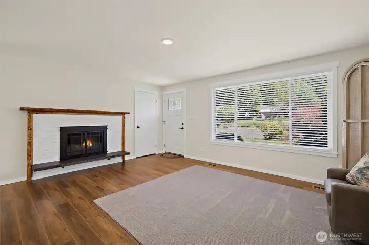 Cozy wood burning fireplace has a wood live edge mantle that is just gorgeous!