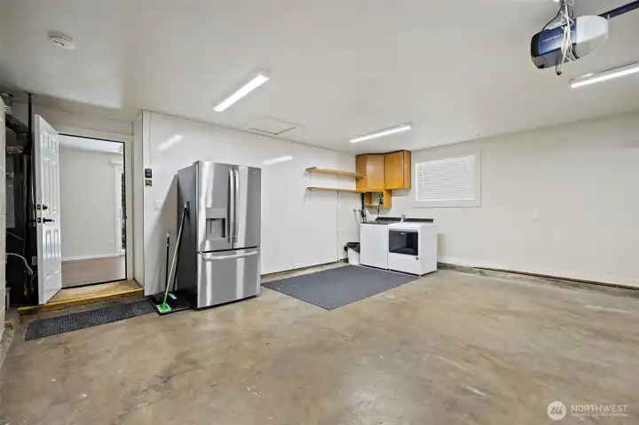 Roomy finished two car garage with laundry space. Refrigerator, W&D stay adding value!