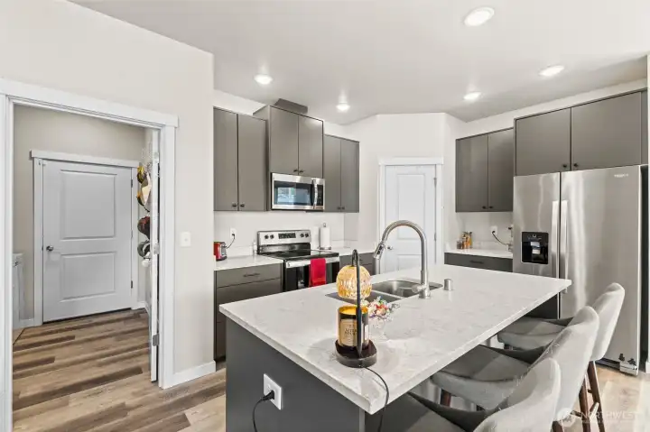 Kitchen with quartz countertops and stainless steel appliances.
