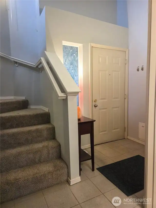 This is the front entry way with stairs leading to the upper level where you'll find the 3 bedrooms, 2 bathrooms, and laundry room.  The door to the attached garage is just out of view to the right of the front door, and the powder room / guest bathroom just out of view at the close right.
