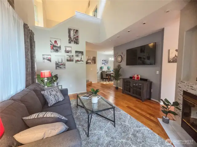 This is looking from the back slider to the dining room, entry way and above to the stairway to the upper level. The soaring ceilings and circular floor plan create a spacious and open living space.