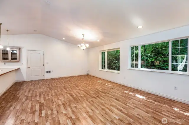View of great room and dining area. Door leads to large two car garage.
