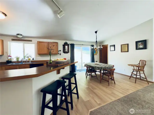 View from hallway towards kitchen, dining room and mud/ laundry room beyond, sliding glass door to back patio and garden boxes