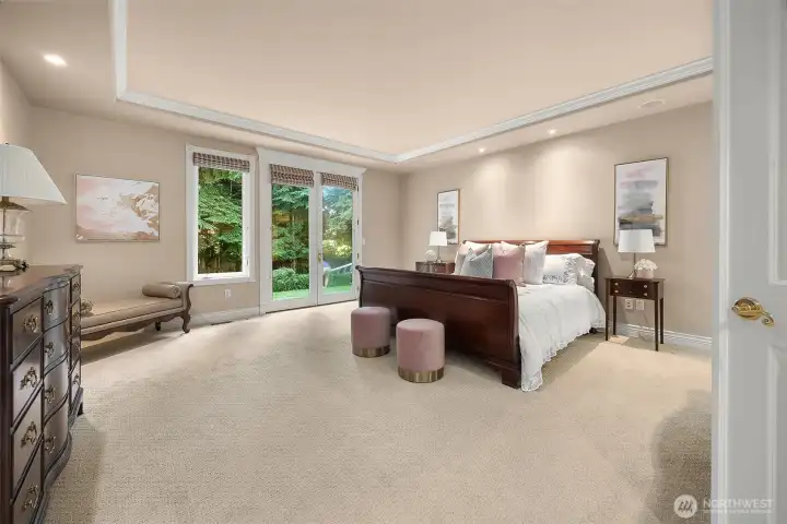 primary bedroom with double french to the tranquil backyard with paved walkway and manicured backyard