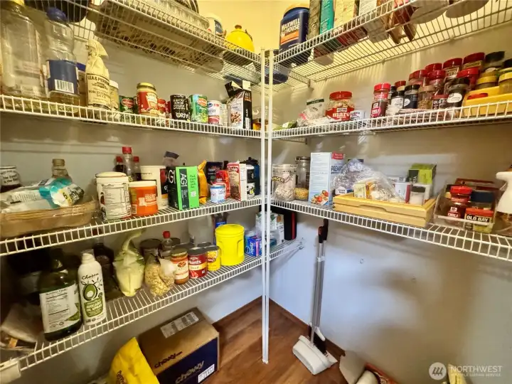 This walk-in pantry has loads of storage. The Luxury Vinyl Plank flooring extends into here from the kitchen.