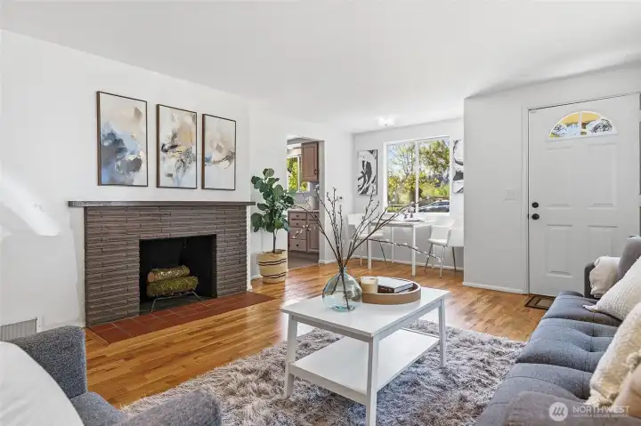 Formal living room with a wood burning fireplace, hardwood floors and opens to the dining area with views of Cromwell Park and light and bright western exposure