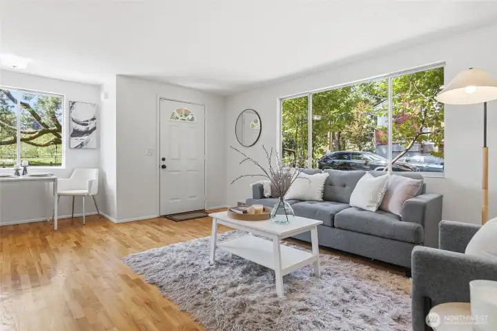 Formal living room with a wood burning fireplace, hardwood floors and opens to the dining area with views of Cromwell Park and light and bright western exposure