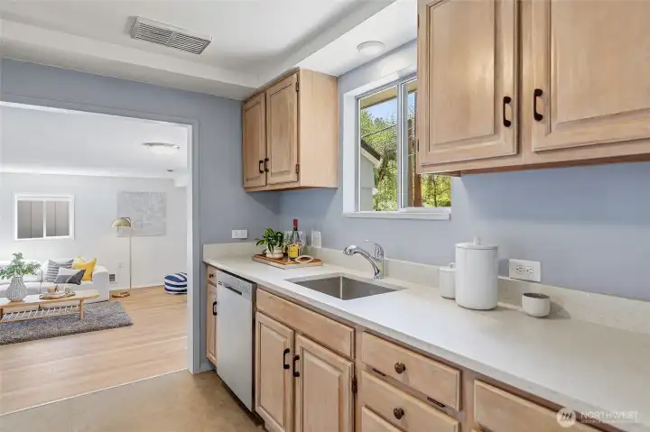 Updated galley style kitchen with quartz counters, refaced cabinets and stainless appliances opens to family room and to the dining area/living room.