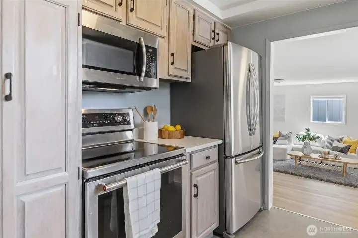 Updated galley style kitchen with quartz counters, refaced cabinets and stainless appliances opens to family room and to the dining area/living room.