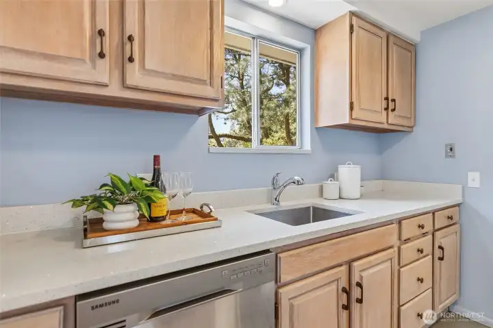 Updated galley style kitchen with quartz counters, refaced cabinets and stainless appliances opens to family room and to the dining area/living room.
