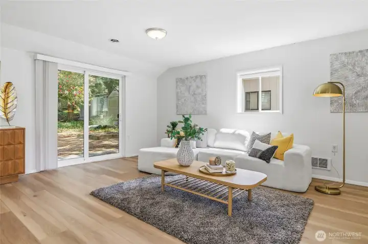 Spacious family room with luxury vinyl plank flooring, sliding door to back yard and back patio.  Barn door to updated 3/4 bathroom and laundry room.