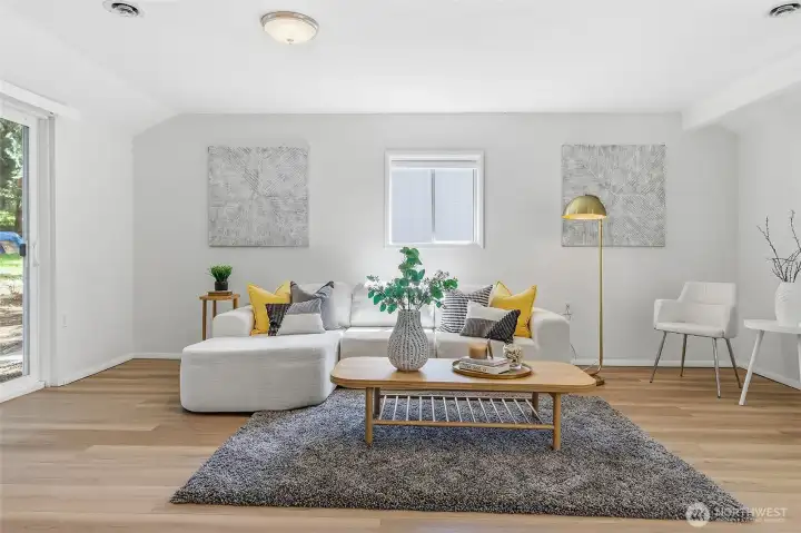 Spacious family room with luxury vinyl plank flooring, sliding door to back yard and back patio.  Barn door to updated 3/4 bathroom and laundry room.