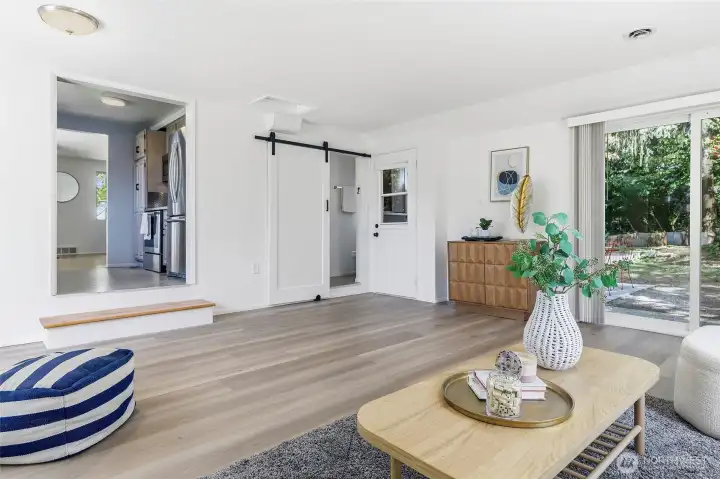 Spacious family room with luxury vinyl plank flooring, sliding door to back yard and back patio.  Barn door to updated 3/4 bathroom and laundry room.