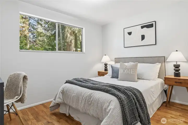 Main floor bedroom #2 with hardwood floors and views out to the backyard.
