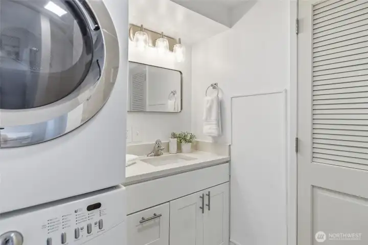 Main floor remodeled 3/4 bathroom accessed view sliding barn door from the family room with a stack washer and dryer.