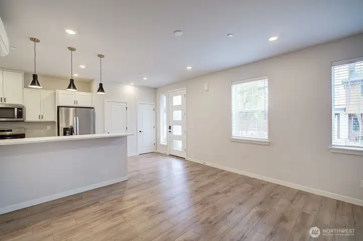 Open and bright living room flows into the eating bar of the kitchen.