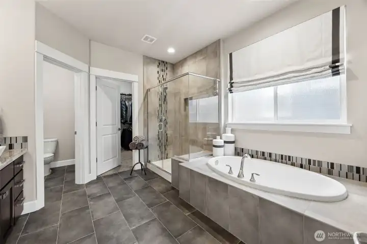 Primary 5 piece bath with walk in closet- tasteful tile and privacy window