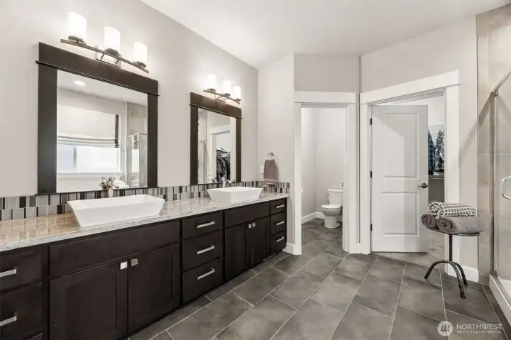 Counter space for everything- wood wrapped mirrors and tile floors compliment