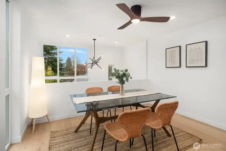 Airy and inviting dining space with clean modern finishes, a stylish ceiling fan, and bright windows creating the perfect setting for everyday meals or casual entertaining.