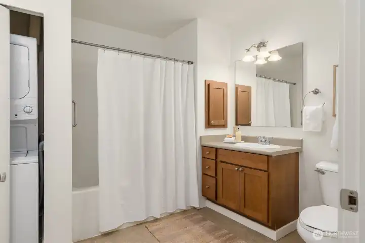 The generously sized bathroom offers stackable laundry and more storage space. The generously sized bathroom offers stackable laundry and more storage space.