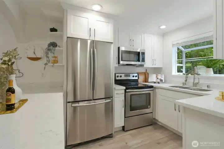 Quartz countertops, stainless steel appliances and beautiful white shaker cabinets.