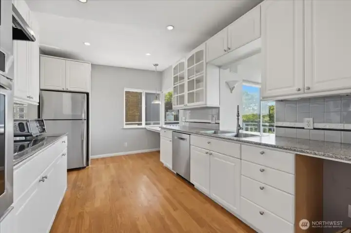 Crisp and clean white cabinets are highlighted by granite countertops and a complementing backsplash.