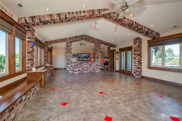 The upstairs huge bonus room, with tile flooring, brick-arched ceiling, ceiling fan and expansive views.  There are built-in window seats along one side of the room