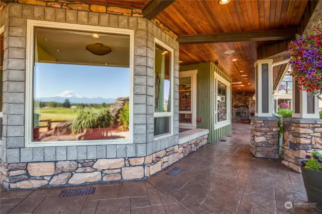 The outside area features a custom wrap-around covered porch, stamped concrete walkways,  extensive wood soffit ceilings and recessed lighting, and rock embellishments