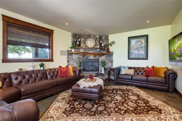 The family room with a river rock gas fireplace for warmth and ambience