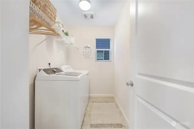 Large laundry room with space for hanging clothes and extra storage