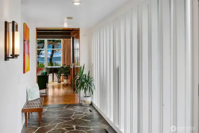 A study in mid-century restraint, the main-level Gallery Hall draws on Tucker & Shields’ mastery of rhythm and proportion. With slate flooring underfoot, crisp vertical panels to the right, and framed views ahead, this transitional space balances architecture and art, movement and pause.