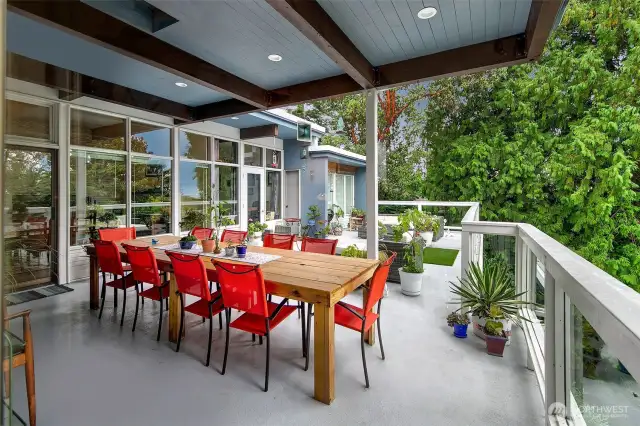 The Covered Deck off the main level extends the home’s social heart outdoors—an all-season gathering space suspended in treetops. With overhead beams, integrated lighting, and seamless flow from the dining and kitchen areas, it’s ideal for everything from sunrise coffee to sunset dinners under a canopy of Northwest sky.