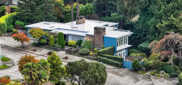 From this southwest perspective, the home’s signature basalt chimney anchors the façade—an iconic material often used in Pacific Northwest mid-century architecture for its strength, texture, and regional resonance. At 4221 W Armour, the stone rises with quiet authority, balancing the crisp lines of Tucker & Shields’ modernist design with a sense of permanence rooted in the land itself.