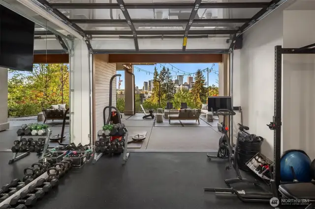 This home gym is an awesome place to work out with a roll up garage door to showcase the stunning views and floor to ceiling mirrored wall to assist with your workouts.