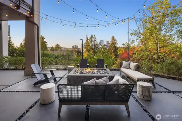 This patio has a built in fireplace, oversized pavers, hanging Edison lights and views to die for.