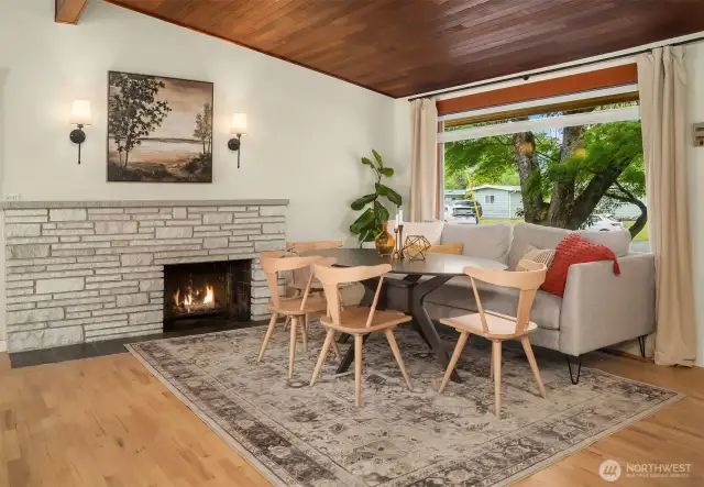 Enjoy meals next to a cozy wood-burning fireplace and a picture window that fills the space with natural light.
