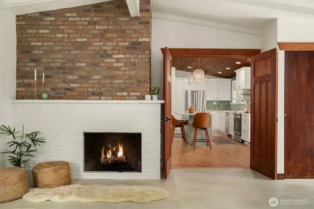The wood-burning fireplace is a warm focal point, flanked by double doors that offer flexible living from the great room into the Kitchen.
