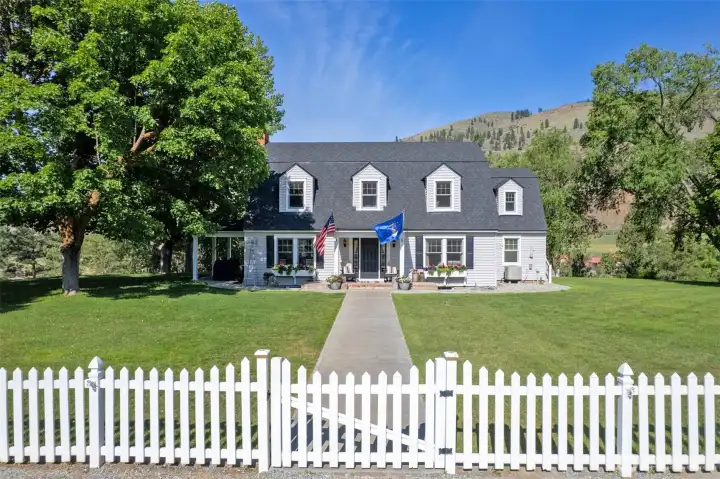The heart of Marble Ranch—a lovingly preserved 1930s farmhouse with classic dormers, covered porch, updated systems, and timeless curb appeal framed by mature trees and manicured lawn.