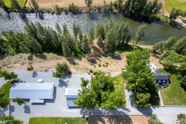 Aerial perspective of Marble Ranch shows the spacious layout: 1930s farmhouse, guest house, and 7,000 SF shop—set just above a half-mile of private Methow River shoreline and forested trails.